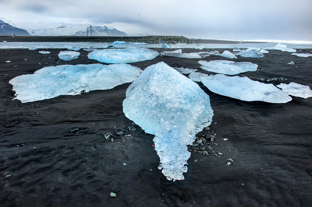黑火山灰沙滩遍布钻石冰块 摄影师定格冰川湖